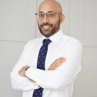 Adregen client giving a testimonial, wearing a white shirt and blue tie